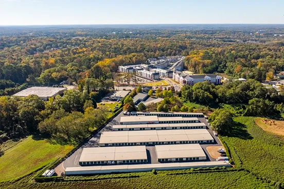 Aerial view of large self storage facility surrounded by trees and nearby residential area